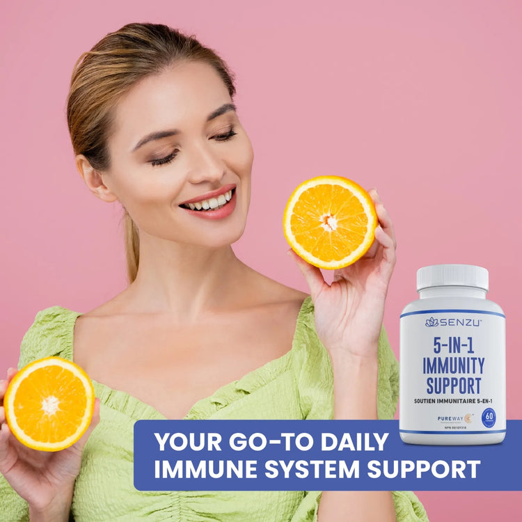 A smiling woman holds two orange halves in front of a pink background, with a bottle of Senzu Health 5-in-1 Immunity Support and the text Your Go-To Daily Immune System Support displayed beside her.